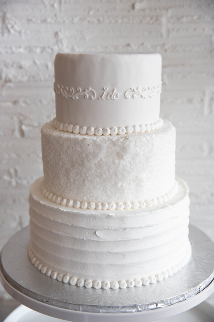 3 tier standard wedding cake from Bethel Bakery with the words "I do" in elegant cursive writing