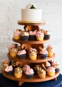 Four Tier Wood Cupcake Stand with assorted chocolate and yellow batter cupcakes placed on each tier. Cupcakes decorated in pink and gold rose designs.